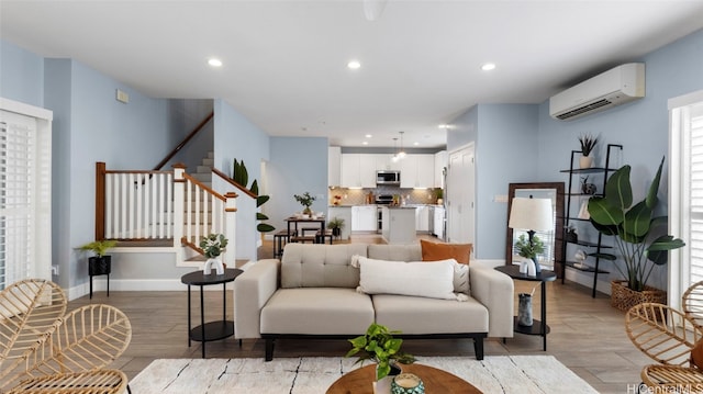 living room with light hardwood / wood-style flooring and a wall unit AC