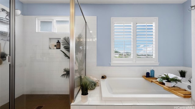 bathroom with plenty of natural light and separate shower and tub