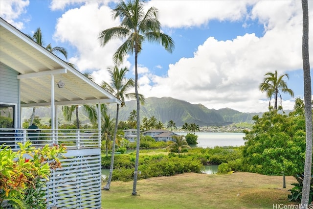 view of home's community featuring a water and mountain view and a lawn