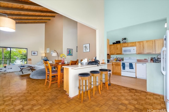 kitchen featuring white appliances, high vaulted ceiling, beamed ceiling, and a kitchen bar