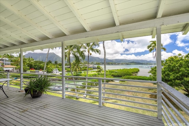 wooden deck with a water and mountain view