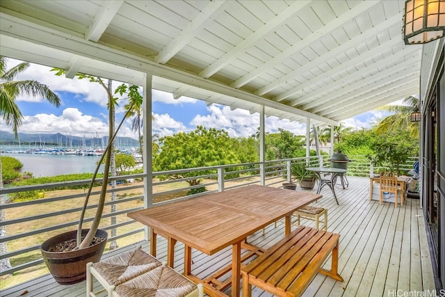 sunroom / solarium featuring plenty of natural light, beam ceiling, wooden ceiling, and a water view