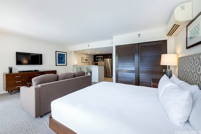 bedroom with an AC wall unit, light colored carpet, and stainless steel refrigerator