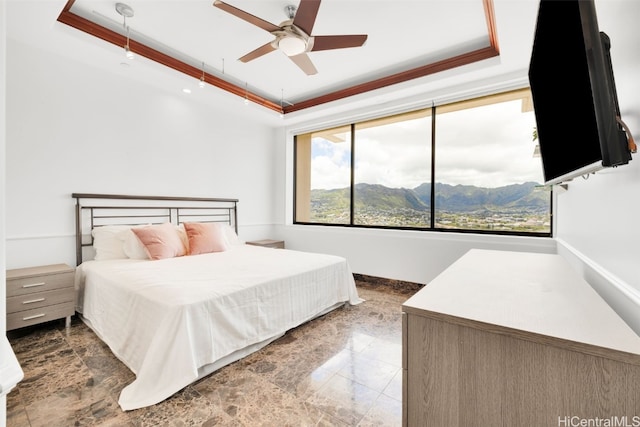 bedroom with ornamental molding, ceiling fan, and a raised ceiling