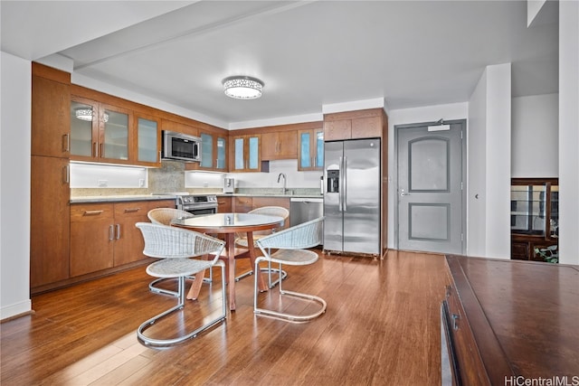 kitchen with stainless steel appliances, sink, and hardwood / wood-style floors