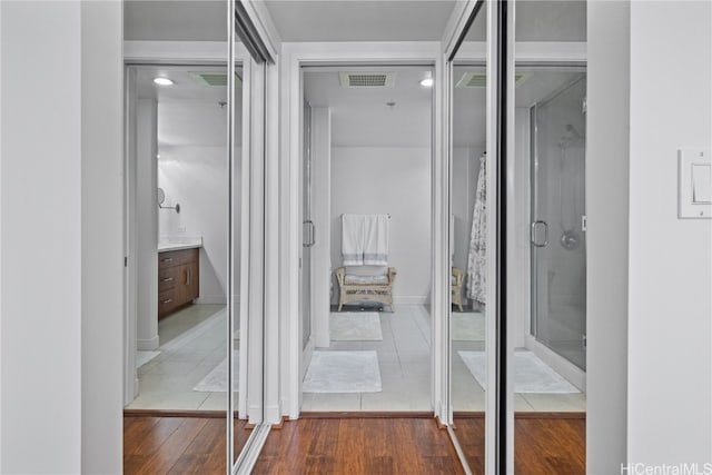 bathroom featuring vanity, a shower with shower door, and hardwood / wood-style floors