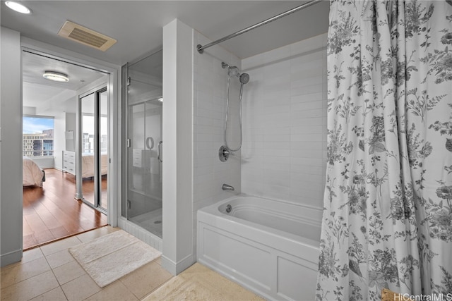 bathroom featuring shower with separate bathtub and wood-type flooring