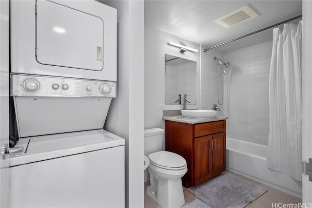 full bathroom with shower / bath combo with shower curtain, toilet, stacked washer and dryer, vanity, and tile patterned flooring