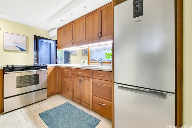 kitchen with light tile patterned flooring, appliances with stainless steel finishes, sink, and a wall unit AC