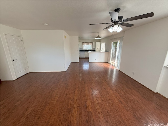 unfurnished living room with dark hardwood / wood-style floors and ceiling fan