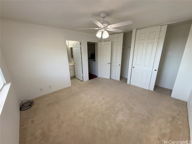 unfurnished bedroom with ceiling fan, light colored carpet, connected bathroom, and two closets