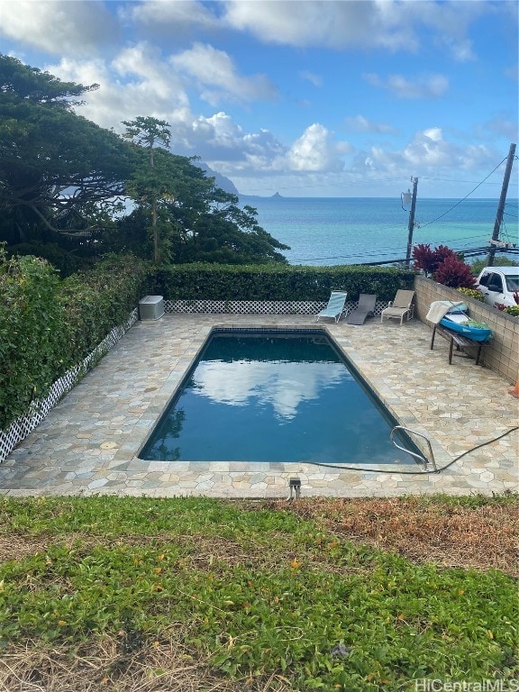 view of swimming pool featuring a water view and a patio area