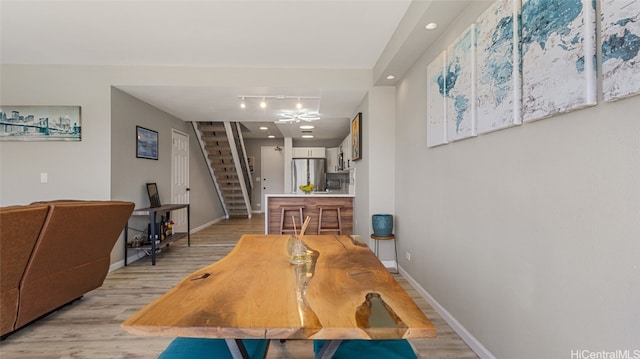 dining room featuring a notable chandelier, light wood-type flooring, and rail lighting