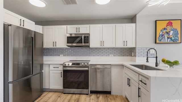 kitchen with sink, white cabinets, and stainless steel appliances