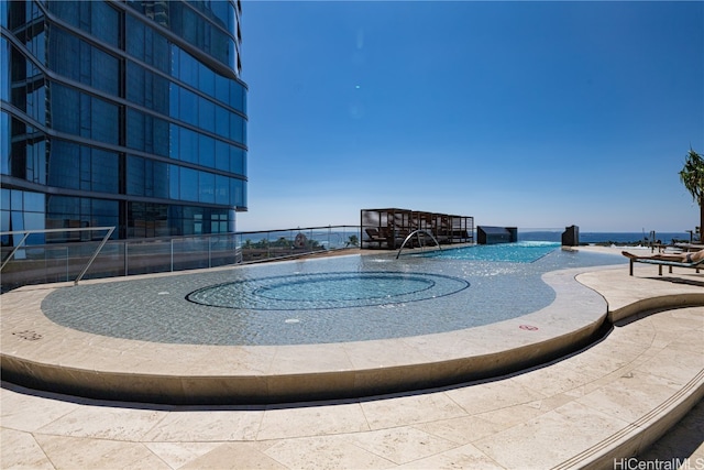 view of swimming pool featuring pool water feature and a water view