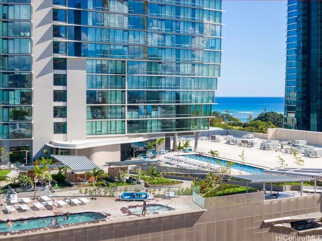 view of property with a community pool and a water view