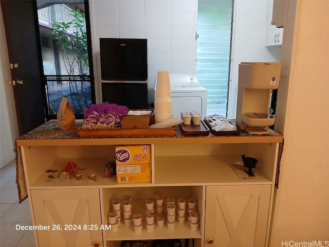 interior details featuring washer / clothes dryer and black fridge