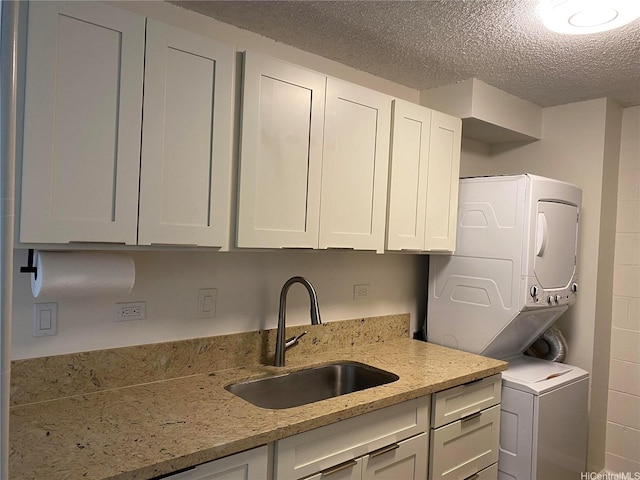 1260 Richard Ln Unit 406, Honolulu, HI 96819 - clothes washing area with stacked washer / dryer, a textured ceiling, and cabinet space
