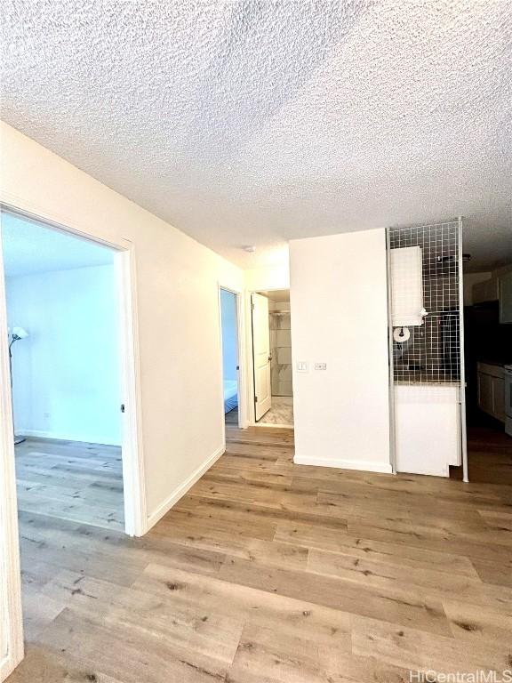 spare room with light hardwood / wood-style flooring and a textured ceiling