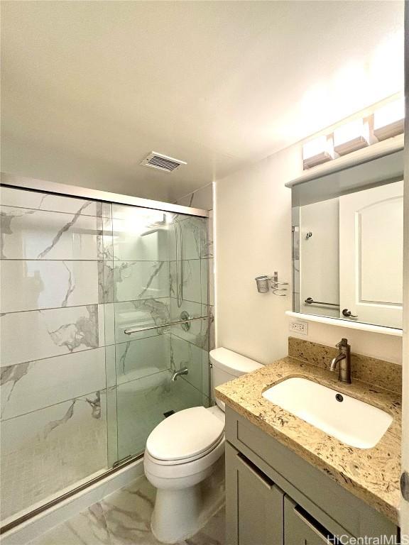 bathroom with vanity, toilet, and an enclosed shower