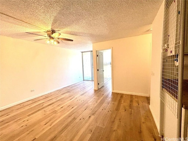 spare room with a textured ceiling, light wood-type flooring, and ceiling fan