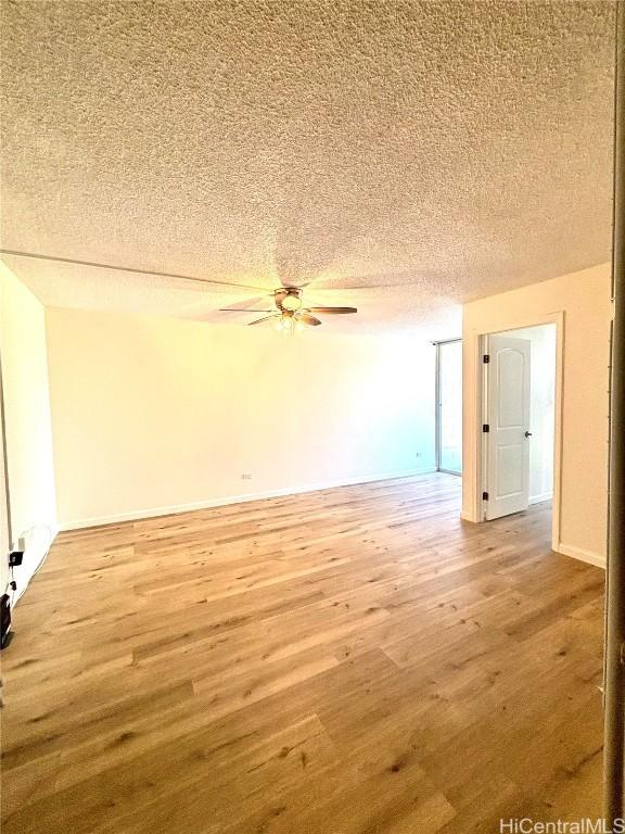 spare room with hardwood / wood-style floors, ceiling fan, and a textured ceiling