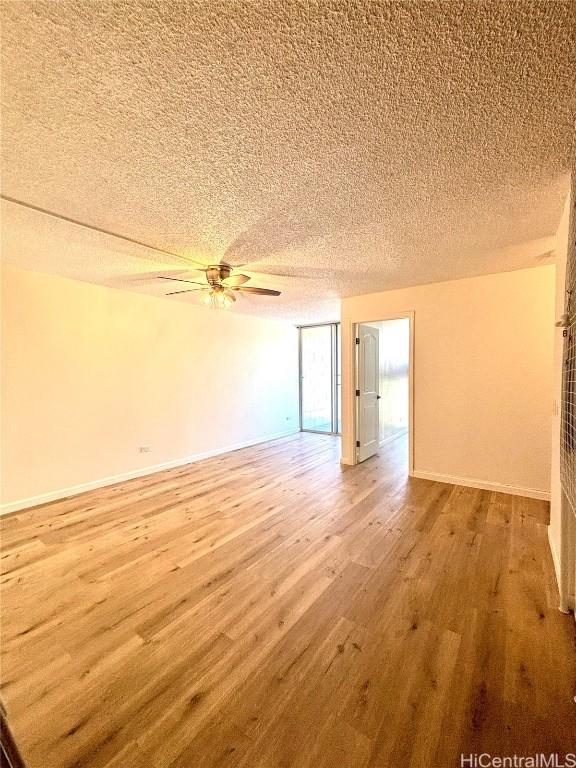 interior space with ceiling fan, a textured ceiling, and hardwood / wood-style flooring