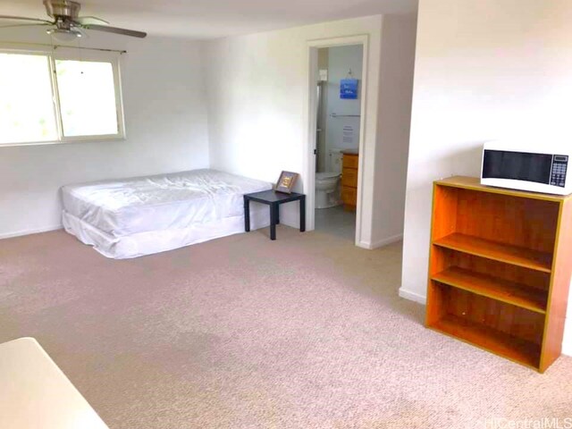 bedroom featuring ensuite bathroom, baseboards, carpet, and ceiling fan