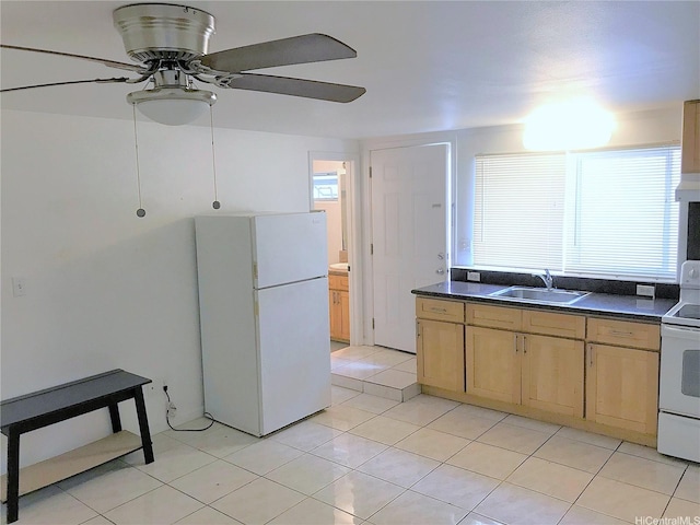 kitchen featuring a sink, dark countertops, white appliances, light brown cabinets, and light tile patterned floors