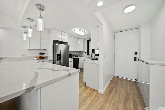 kitchen with kitchen peninsula, stainless steel fridge, decorative light fixtures, white cabinets, and light hardwood / wood-style flooring