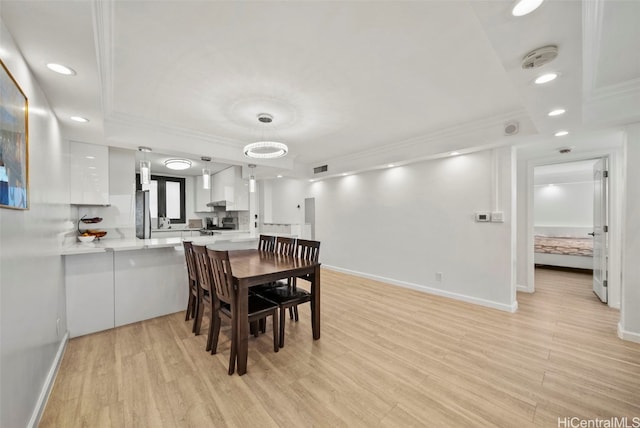 dining space with light hardwood / wood-style floors and ornamental molding