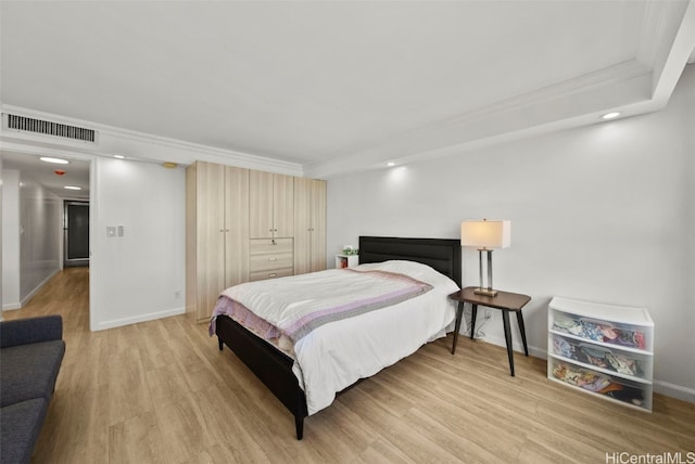 bedroom with ornamental molding and light hardwood / wood-style flooring