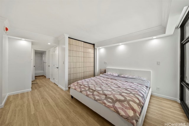 bedroom with ornamental molding and light hardwood / wood-style flooring