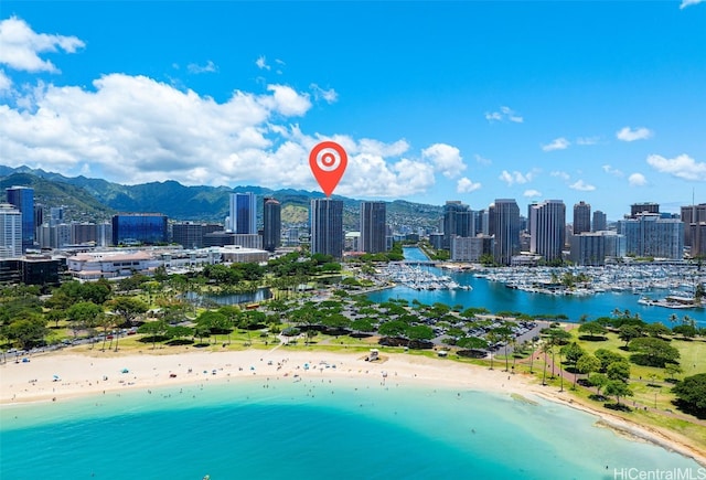 drone / aerial view featuring a water and mountain view and a view of the beach