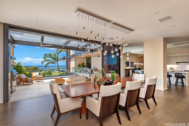 dining area featuring ceiling fan, expansive windows, and hardwood / wood-style floors