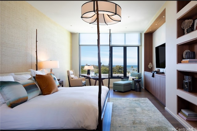 bedroom with dark hardwood / wood-style flooring, multiple windows, and floor to ceiling windows