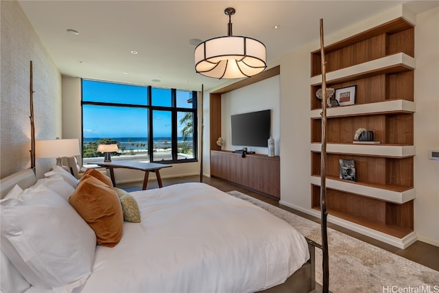 bedroom featuring expansive windows and hardwood / wood-style flooring