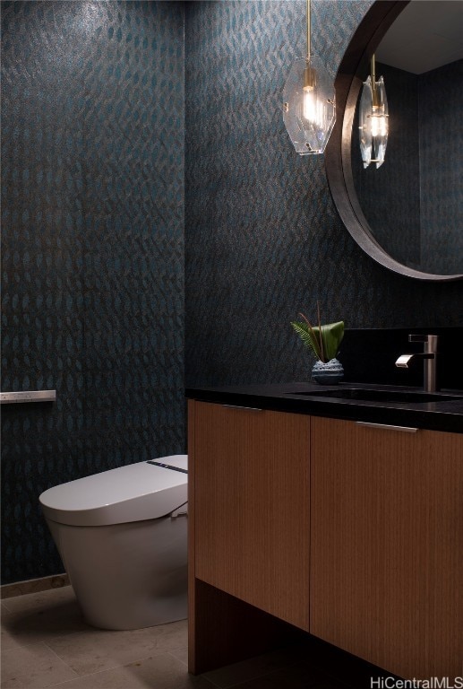 bathroom with toilet, vanity, and tile patterned floors