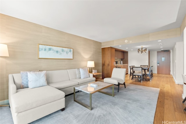 living room with an inviting chandelier and light hardwood / wood-style flooring