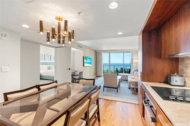 dining room featuring light hardwood / wood-style flooring, a notable chandelier, and floor to ceiling windows