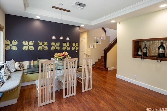 dining area with crown molding, dark hardwood / wood-style floors, and a tray ceiling