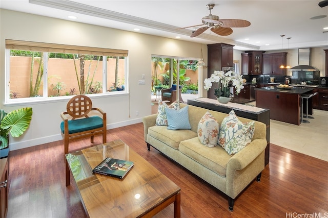 living room with dark hardwood / wood-style flooring, ceiling fan, and plenty of natural light