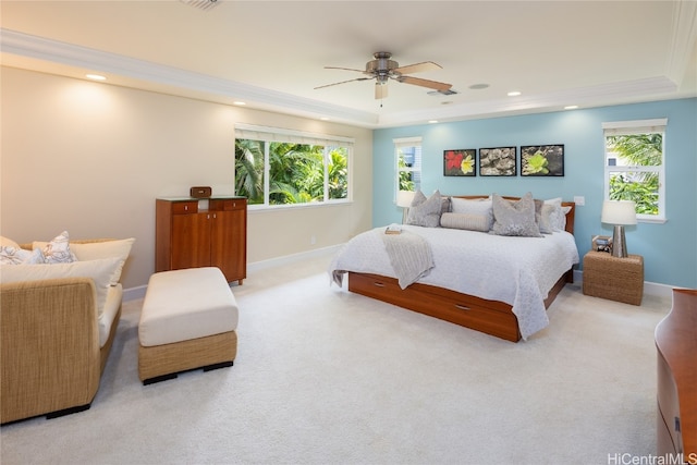 carpeted bedroom featuring multiple windows, ornamental molding, a raised ceiling, and ceiling fan