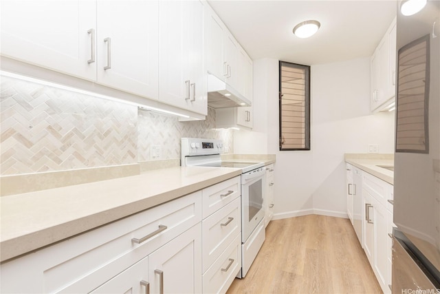 kitchen featuring light countertops, under cabinet range hood, white range with electric cooktop, and tasteful backsplash