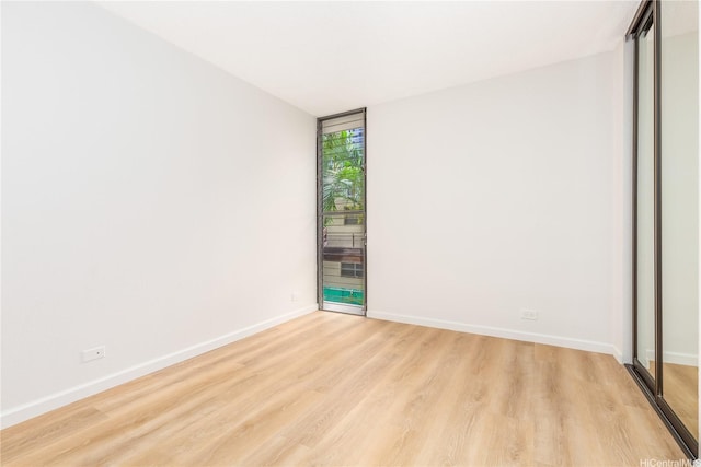 spare room featuring light wood-style flooring and baseboards