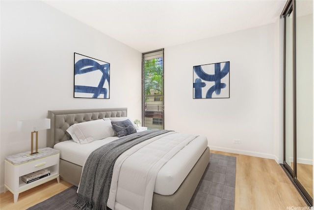bedroom with baseboards and wood finished floors