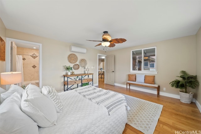 bedroom with hardwood / wood-style floors, ceiling fan, a wall mounted air conditioner, and ensuite bath