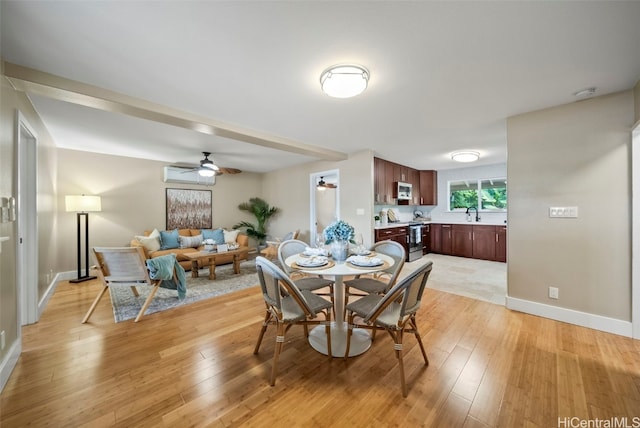 dining space featuring a wall mounted air conditioner, light wood-type flooring, and ceiling fan