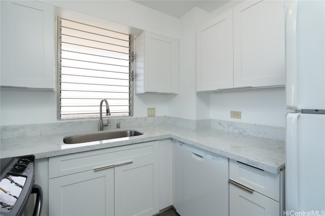 kitchen with white cabinetry, light stone countertops, sink, and white appliances