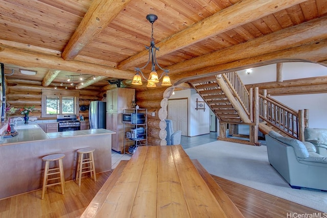 16-1125 Poouli Rd, Kurtistown, HI 96760 - unfurnished dining area featuring log walls, a sink, light wood finished floors, a chandelier, and stairway